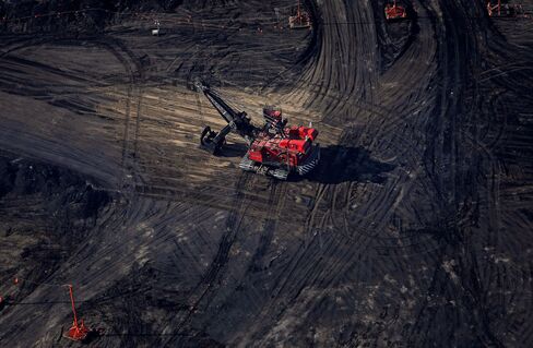 A bucket loader digs for oil sands at a mine in this aerial photograph taken near Fort McMurray, Alberta, Canada, on June 4, 2015.
