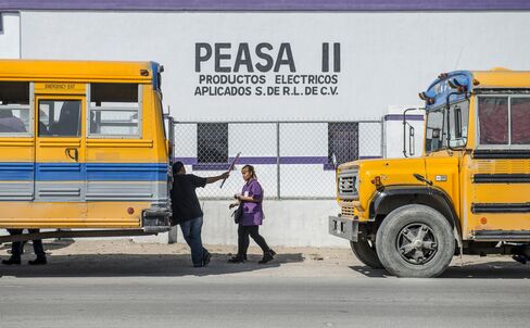 Factory workers at a Regal Beloit Corp. plant, also known as Peasas II, walk to the buses that will take them home after their shift has ended in Acuna, Mexico.