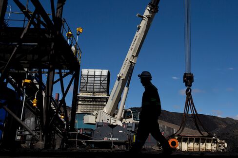 An employee walks past a Terex Corp. crane at the coal handling and preparation plant (CHPP) of Energy Resources LLC, a subsidiary of Mongolian Mining Corp. (MMC), in Tsogttsetsii, Omnugovi province, Mongolia, on Thursday, June 19, 2014. Mongolia's Vice Minister for Mining Erdenebulgan Oyun said mining law amendments would increase Mongolia's area available to mining and exploration to 20 percent from around 8 percent, by lifting a 2010 ban on new licenses. The period of exploration would also increase from nine years to 12 years. Photographer: Brent Lewin/Bloomberg