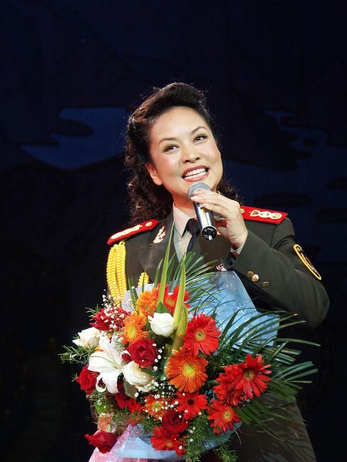 Flowers from a fan? Peng Liyuan, aka Mrs Xi Jinping, belts out a paean to China in Henan Province in 2004.