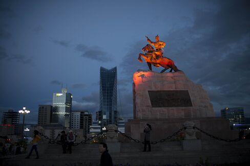 An illuminated statue of Damdid Sukhbaatar, right, stands on Chinggis Khaan Square.