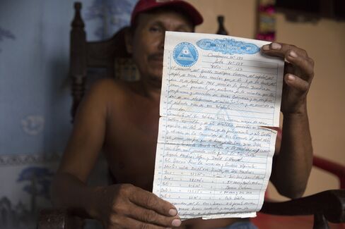 A resident holds his land contract near the Hacienda Miramar, where work has started on the canal in Rio Grande, Nicaragua.