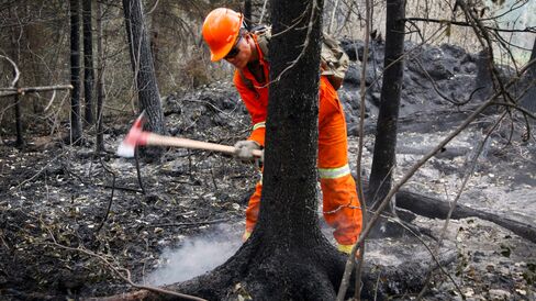 A member of the Canadian Forces puts out hotspots from wildfires near Montreal Lake, Saskatoon, on July 9.
