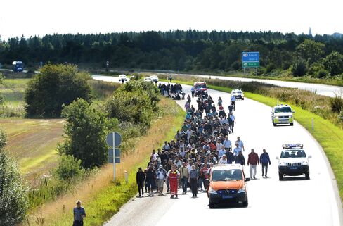 Migrants walk the freeway near the Danish-German border heading north to Sweden