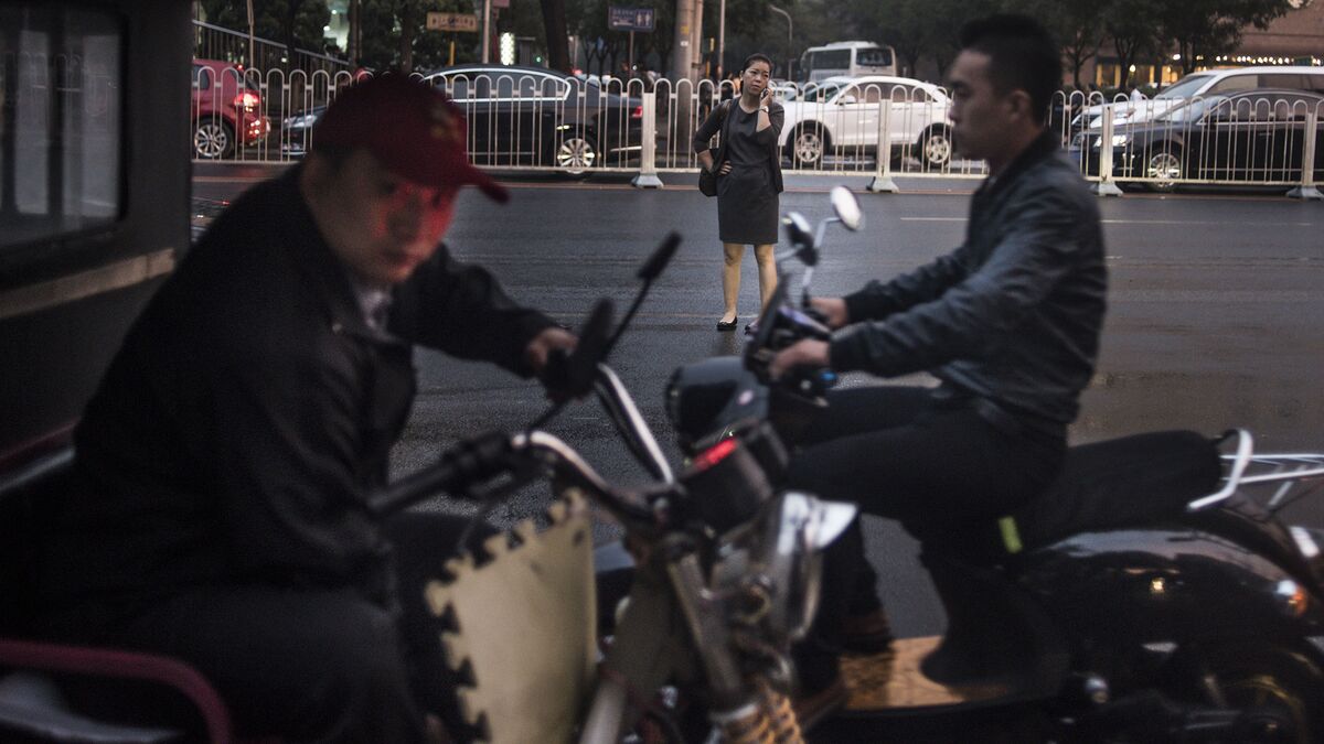 A man waits for clients to ride on his tricycle in Beijing.
