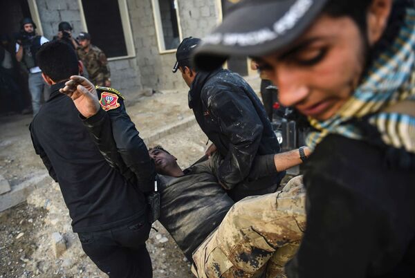 Iraqi Counter Terrorism Service (CTS) members carry an injured comrade during clashes with Islamic State (IS) group jihadists near the village of Bazwaya, on the eastern edges of Mosul, on October 31, 2016.