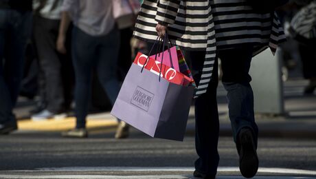 A pedestrian carries a Louis Vuitton shopping bag on Black Friday