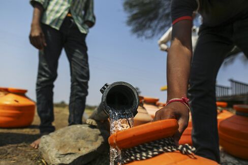 People filling vessels from a ground water tap in Latur, Maharashtra, India.