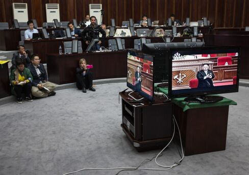 Journalists watch a television broadcast showing a speech by Kim Jong Un.