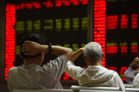 Investors react at a securities company in Beijing on July 14, 2015. Photographer: Greg Baker/AFP/Getty Images