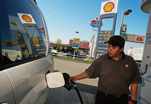 A gas station attendant pumps gas into an SUV at a Shell gas station in Jersey City, New Jersey.
