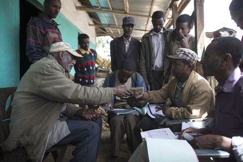 A farmer, left, accepts cash payment for his grain from a buyer in the village of Damo Dulele, Ethiopia, in February 2015. Growth in Ethiopia has beaten every other sub-Saharan country over the past decade. 