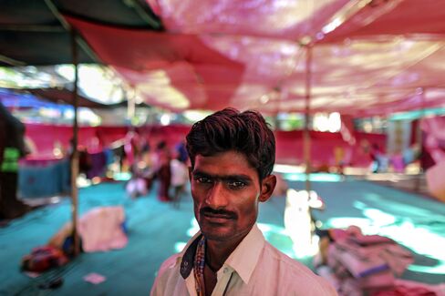 Migrant farmer Vijay Jadhav stands for a photograph inside a temporary shelter in Thane, India.