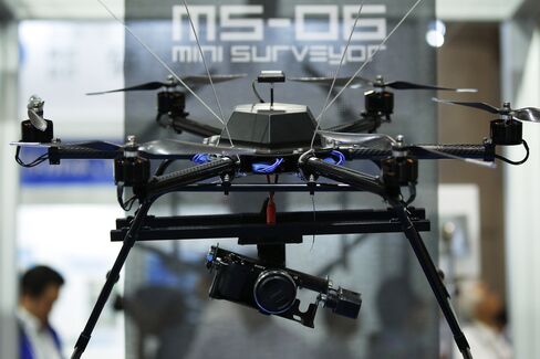 A Sony digital camera is attached to the Autonomous Control Systems Laboratory Ltd. Mini Surveyor MS-06LA multi-rotor unmanned aerial vehicle (UAV), manufactured by Kikuchi Seisakusho Co.
