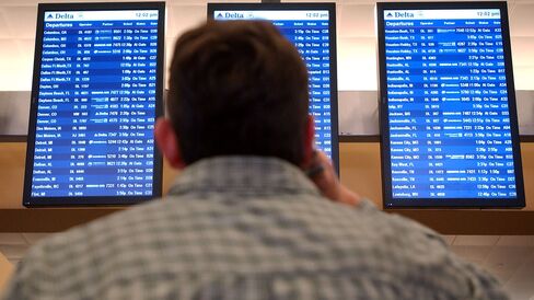 A Delta Airlines passenger reads the flight departure screens at Atlanta Hartsfield-Jackson International Airport.
