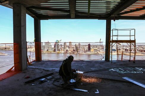 A worker on the unfinished skybridge at the American Copper Buildings with views out to Long Island City, Queens.