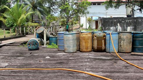 Loading and unloading gasoline barrels on the outskirts of Mabaruma.