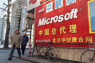 A Chinese couple walks past a sign adver