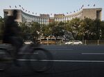 A man rides a bicycle past the People's Bank of China headquarters in Beijing.