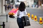 A pedestrian carries shopping bags on Bond Street in London, U.K., on Monday, Aug. 8, 2016. Consumers spent more on new clothes, meals out and day trips in July, according to card transaction data analyzed by Visa and Markit.