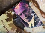 Canadian one hundred dollar banknotes depicting Former Prime Minister Sir Robert Borden and a Canadian one dollar coin