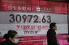 Pedestrians walk past an electronic screen displaying the Hang Seng Index figure in Hong Kong, on Tuesday, Feb. 6, 2018. Hong Kong’s benchmark index's four-day slide accelerated Tuesday, as it tumbled the most since June 2016.