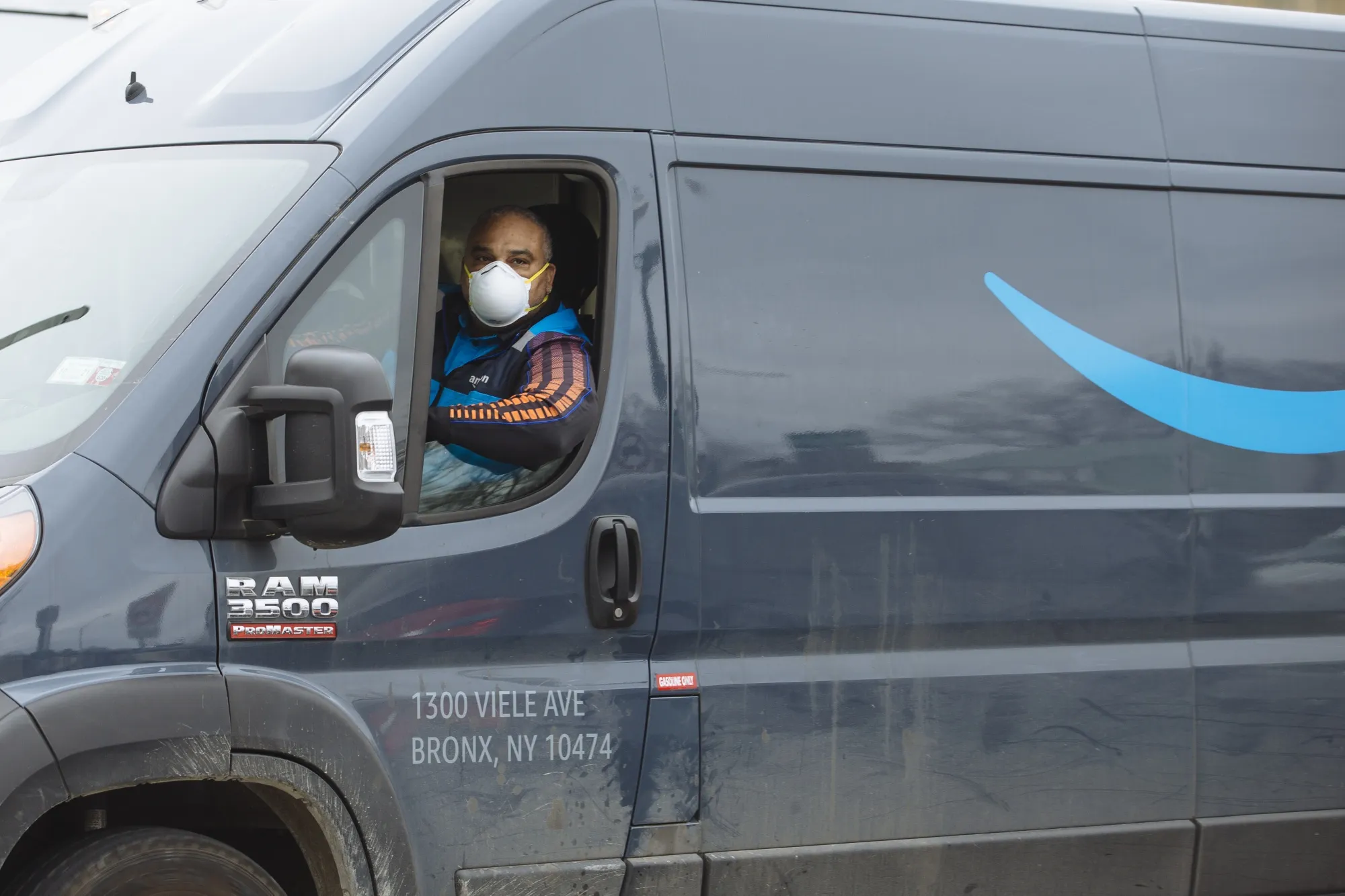 A driver wears a protective mask while traveling in an Amazon.com Inc. delivery truck in New Rochelle, New York, on&nbsp;March 12.&nbsp;