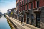 A lone cyclist passes along the banks of the Navigli canal system in Milan. The city is now cautiously exploring how to safely reopen.