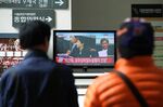 People watch a television screen broadcasting the ruling of former South Korean President Park Geun-hye's corruption charges at the Seoul Central District Court in Seoul, South Korea, on Friday, April 6, 2018