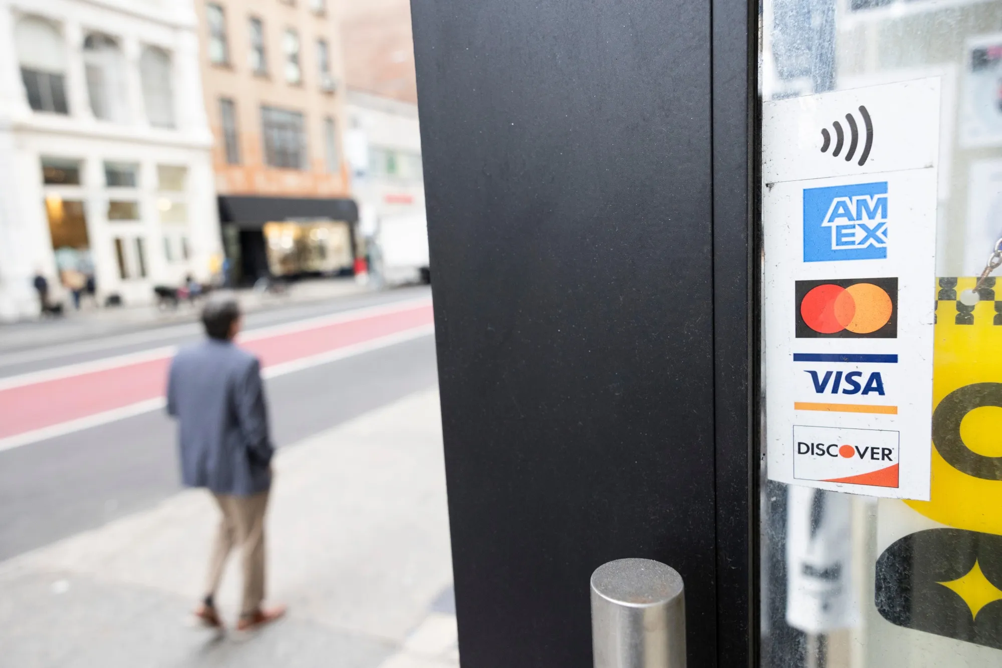 A sticker for American Express, Mastercard, Visa and Discover credit cards displayed at a business in New York.