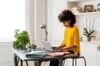 Woman sitting at desk, working, using laptop
