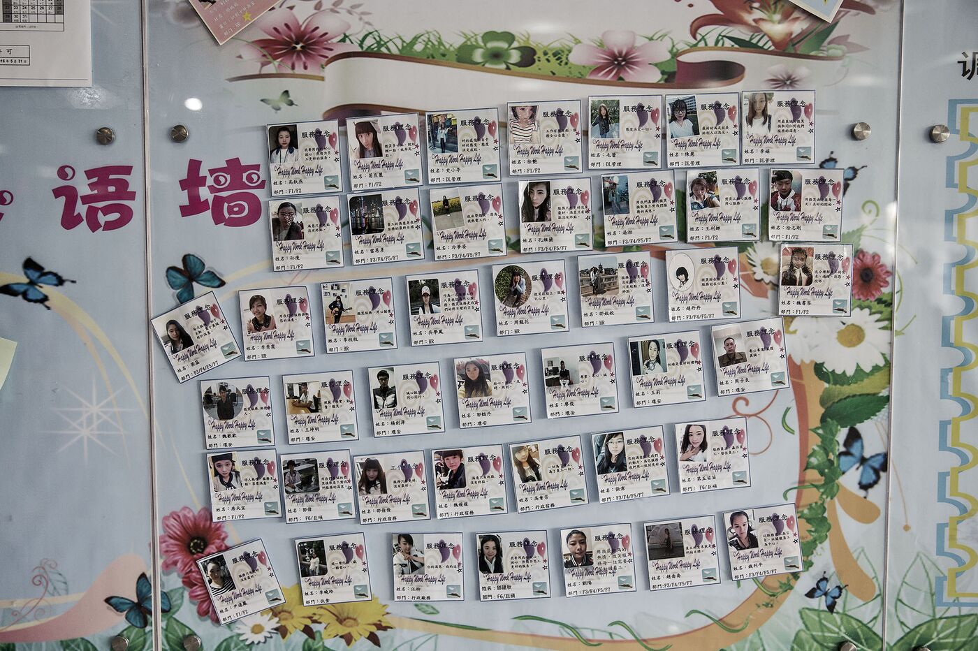 Pictures of workers hang on a wall at an employee service center at a Pegatron factory in Shanghai, China on Friday, 15 April 2016. Photographer: Qilai Shen / Bloomberg