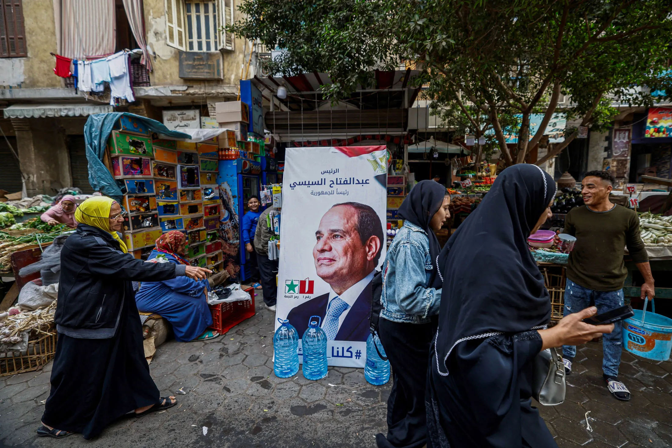 People walk past a campaign poster for Abdel Fattah El-Sisi in Cairo on Dec. 7.