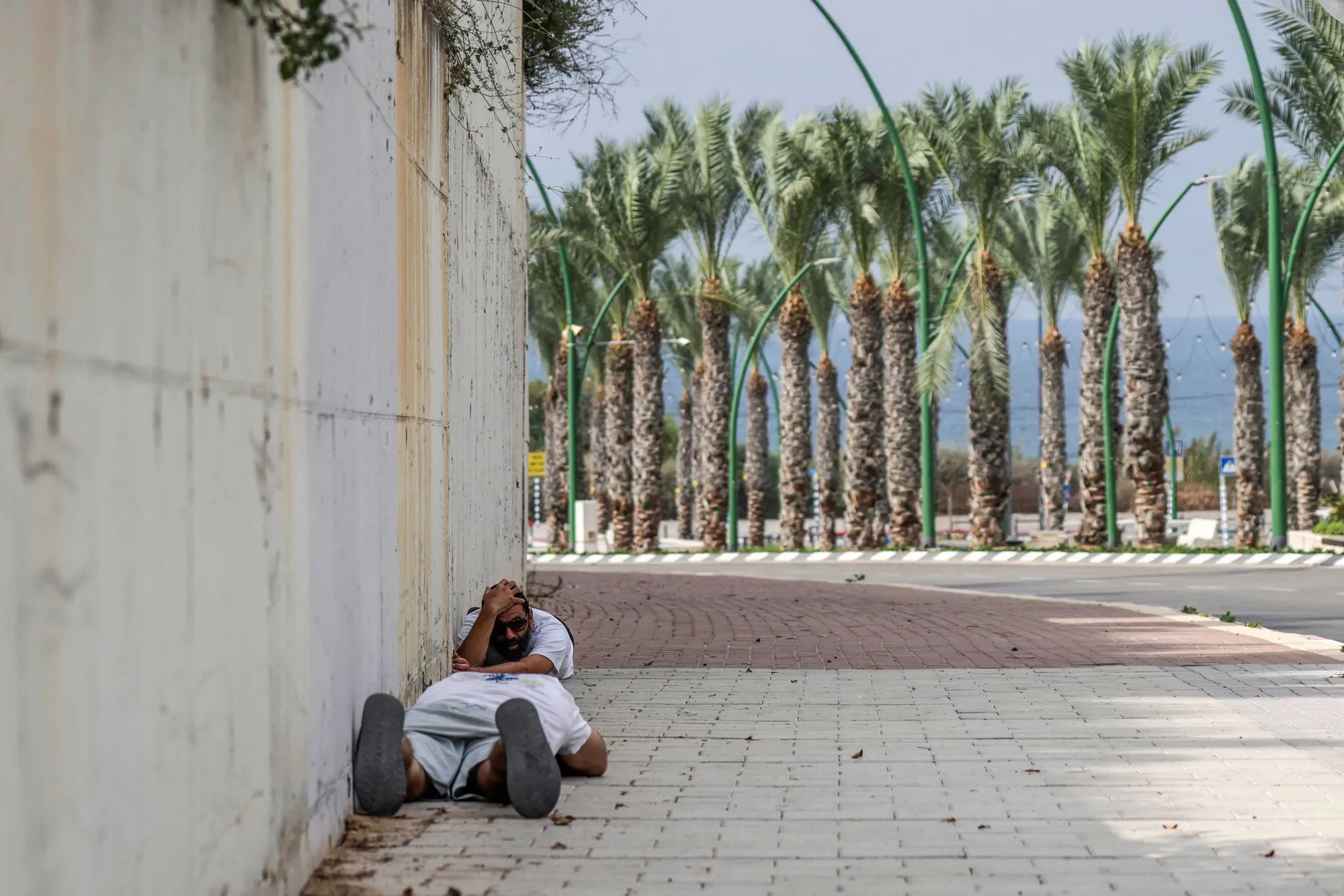 People duck for cover upon hearing sirens warning of incoming fire in&nbsp;Ashkelon on Oct. 11.