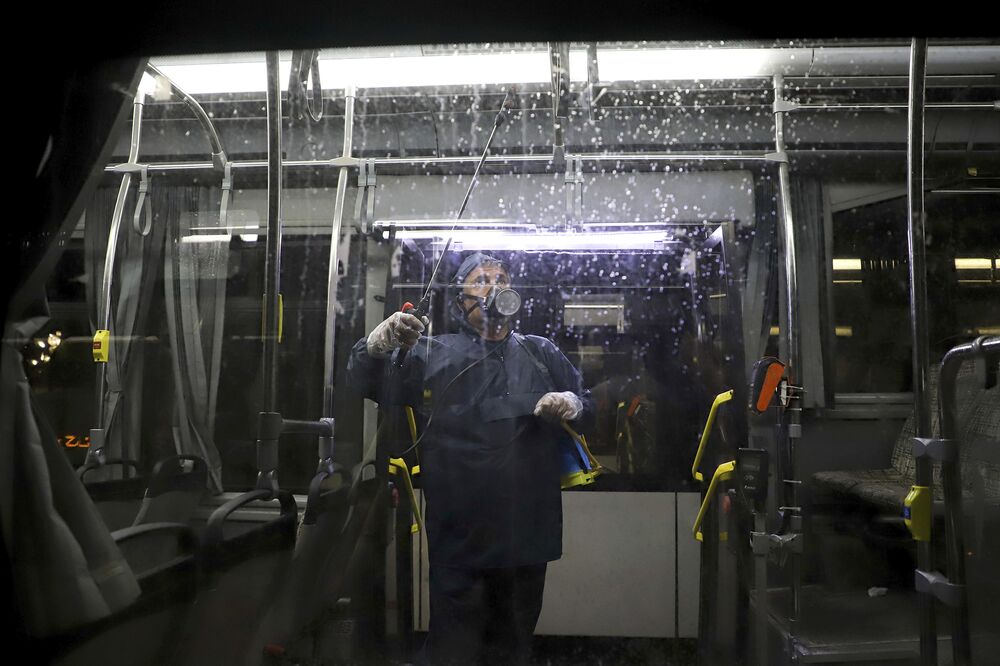A worker disinfects a public bus against coronavirus in the city of Ahvaz in southwestern, Iran, in early morning of Tuesday, Feb. 25, 2020.