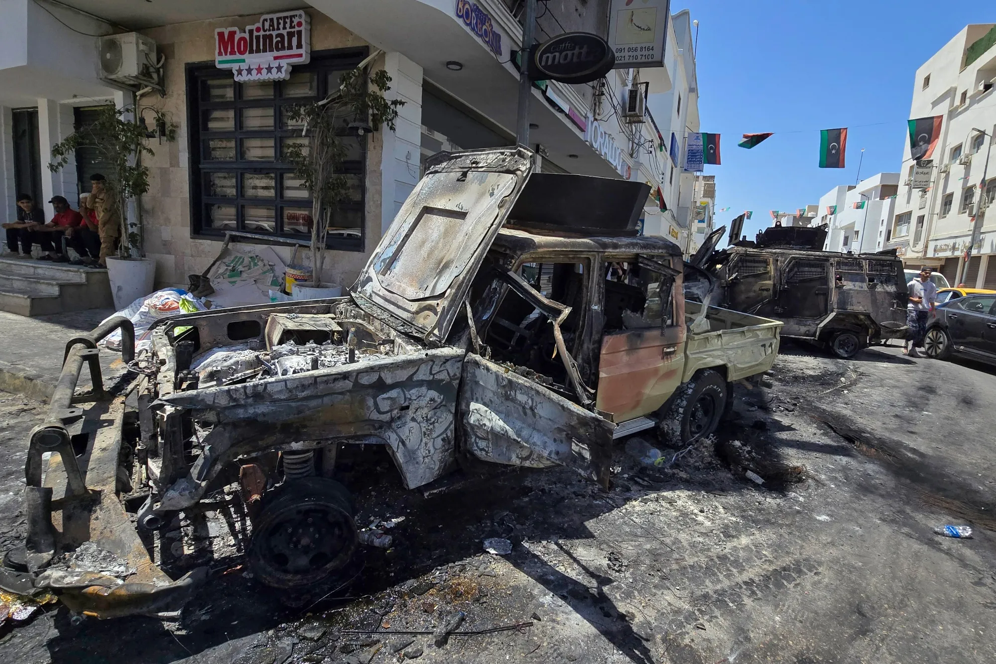 Destroyed vehicles following overnight clashes in in Tripoli, on May 13.