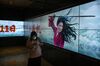 A Chinese woman walks by a screen displaying the trailer for the Disney film Mulan showing Chinese-American actress Liu Yifei on September 11, 2020 at a cinema in Beijing, China.