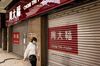 A pedestrian wearing a protective mask walks past a shuttered Chow Tai Fook Jewellery Group Ltd. jewelry store in Macau, China, on Tuesday, March 3, 2020. Casinos in Macau, the Chinese territory that's the world’s biggest gambling hub, reported a record drop in gaming revenue, as they grappled with the cost of closing down their businesses for 15 days to help contain the deadly coronavirus outbreak.