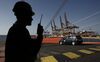 A crew member speaks on a radio as new vehicles are unloaded from the Topeka vehicle carrier at the car terminal in the Port of Piraeus, operated by Piraeus Port Authority SA, in Piraeus, Greece, on Tuesday, Oct. 27, 2015. Greece is aiming to lease 14 regional airports and line up the sale of a majority stake in the port of Piraeus before the end of the year as the government attempts to rev up asset sales that have consistently failed to live up to expectations through successive bailouts.