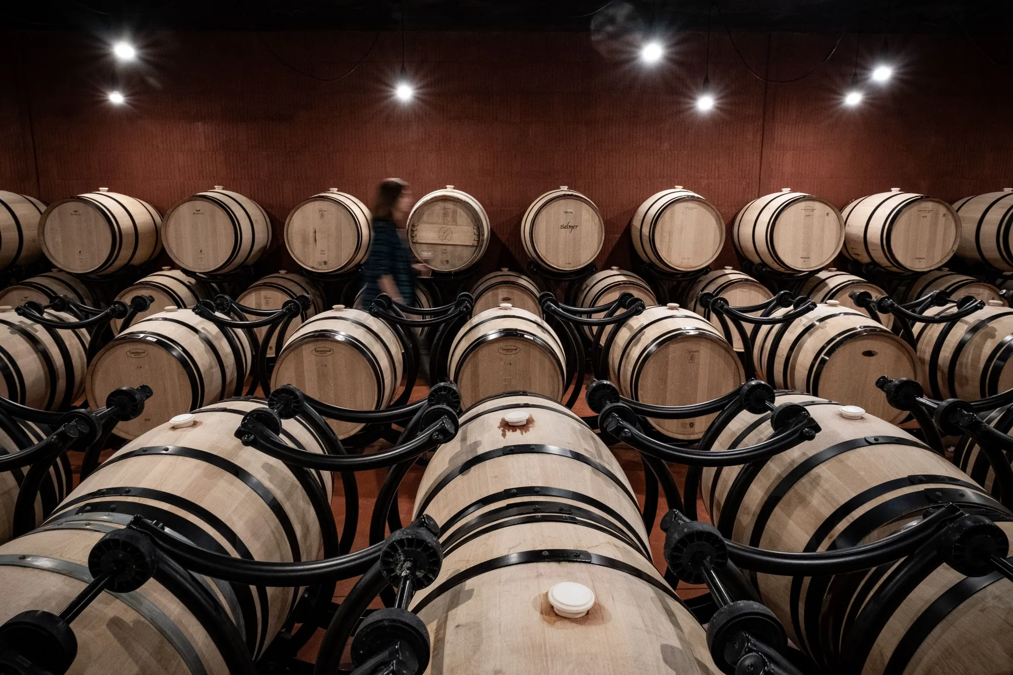 Wine barrels sit in the cellars of Chateau La Dominique vineyard in Pomerol, France.