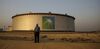 An employee visits the site of crude oil storage tanks at the Juaymah tank farm at Saudi Aramco's Ras Tanura oil refinery and oil terminal in Ras Tanura, Saudi Arabia, on Monday, Oct. 1, 2018. Saudi Aramco aims to become a global refiner and chemical maker, seeking to profit from parts of the oil industry where demand is growing the fastest while also underpinning the kingdom’s economic diversification.