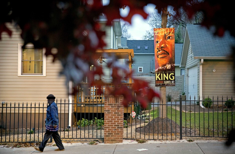 A man walks past a banner of civil rights leader Rev. Martin Luther King Jr., while walking through the Mechanicsville neighborhood in Atlanta. 