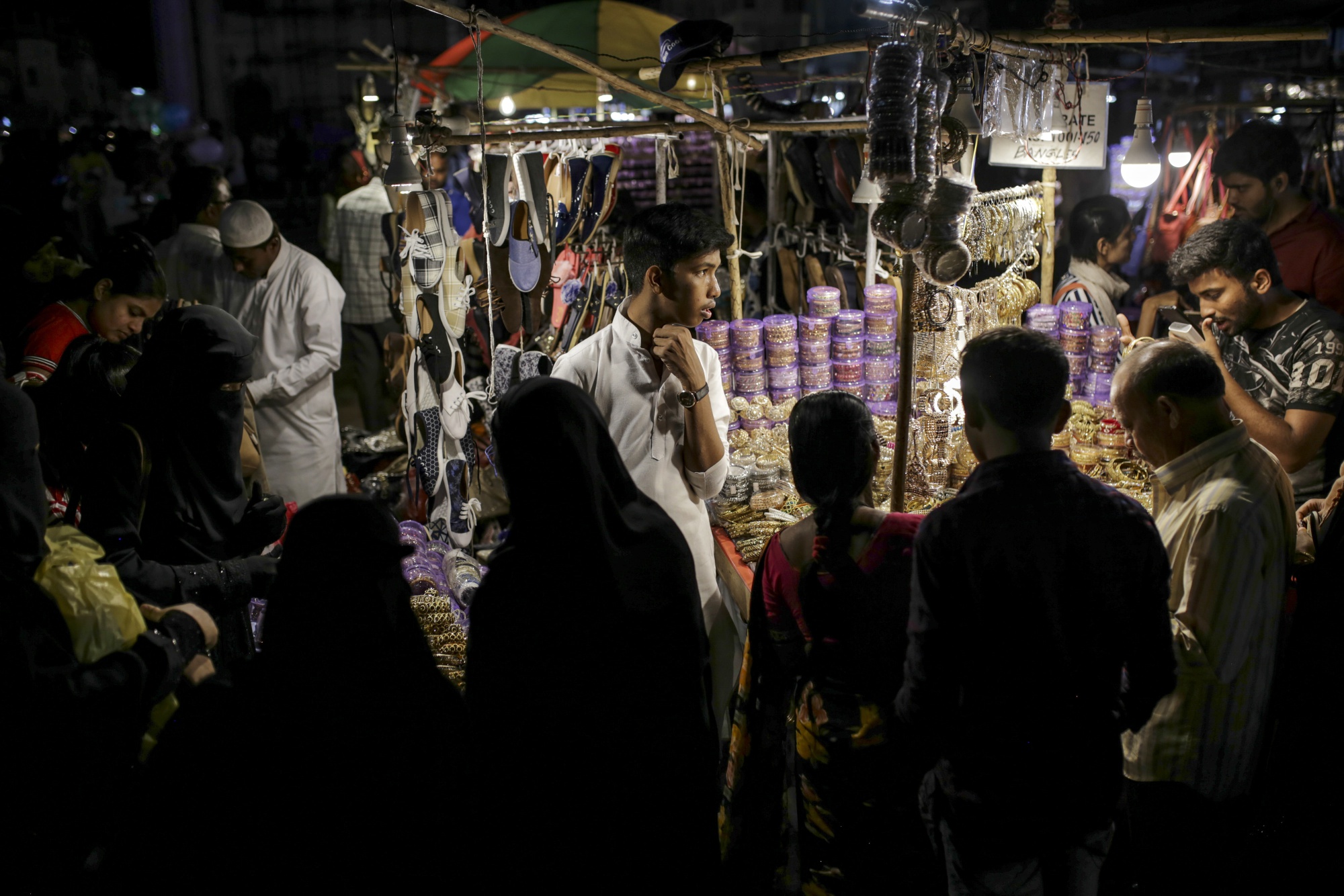 A roadside jewelry vendor attends to customers at a stall in Hyderabad, India.