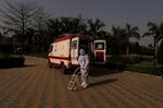 A healthcare worker pushes a trolley for transporting oxygen tanks outside a temporary hospital for Covid-19 patients at a stadium in New Delhi, on April 23.