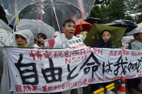 Demonstrators hold a banner as they stage a protest against Japanese Prime Minister Shinzo Abe's controversial security bills in front of the National Diet in Tokyo on Thursday.