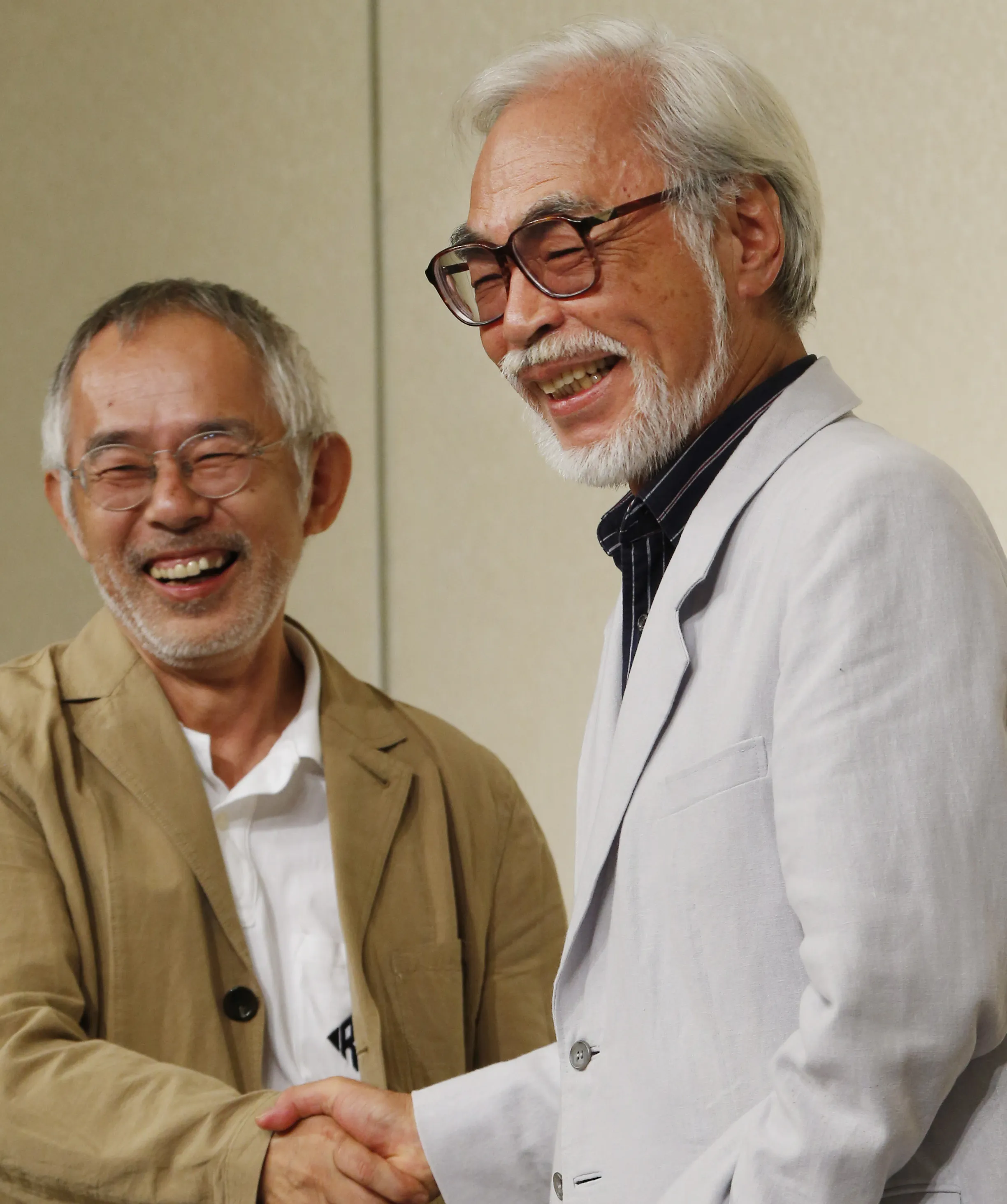 Hayao Miyazaki, right, one of animation's most admired and successful directors, shares a laugh with Toshio Suzuki, chairman and producer of Studio Ghibli Inc., as they shake hands during a news conference on his retirement in Tokyo on Sept. 6, 2013. Ghibli, the Japanese studio that just won its second Oscar for feature animation for “The Boy and The Heron," announced early Monday, March 11, 2024, in Japan, hasn't said yet what it plans next. But founder Hayao Miyazaki, who at 83 was the oldest director ever nominated in that category, won’t rule out making another film, even if his next project is a short instead of a full-length feature. (AP Photo/Koji Sasahara, File)