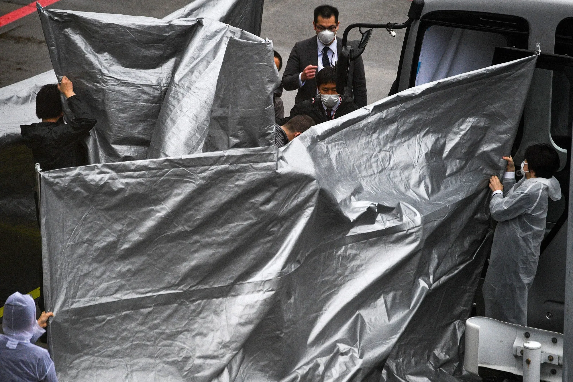 Passengers from the plane believed to be carrying both Michael Taylor and his son Peter board a bus at Narita airport, on March 2.