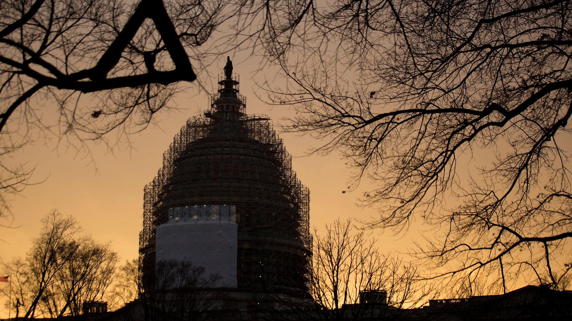 Scaffolding surrounds the U.S. Capitol Building Dome at sunset in Washington, D.C., U.S., on Tuesday, Dec. 9, 2014.

