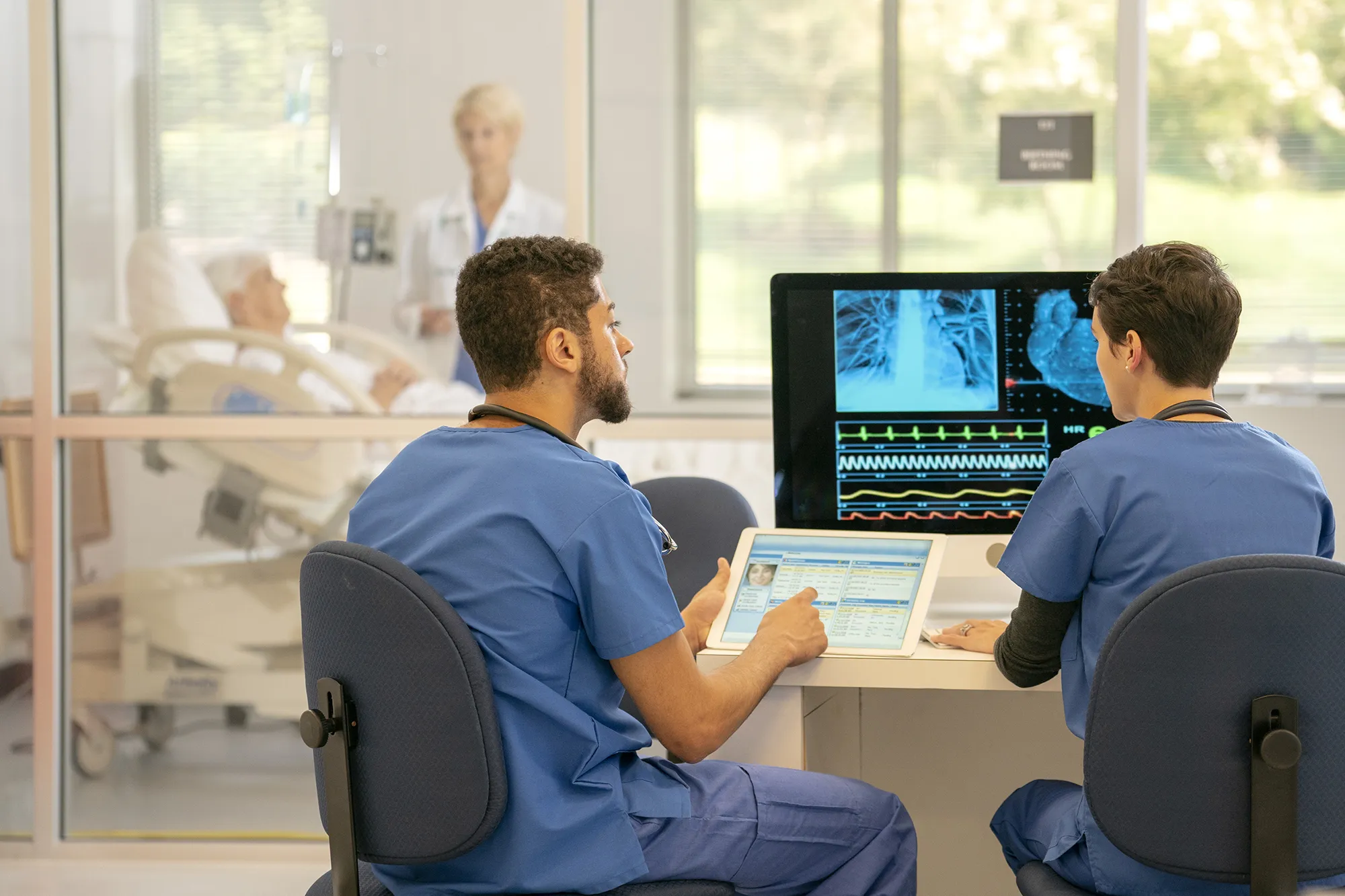 Healthcare workers look over a patient’s chest x-ray.&nbsp;