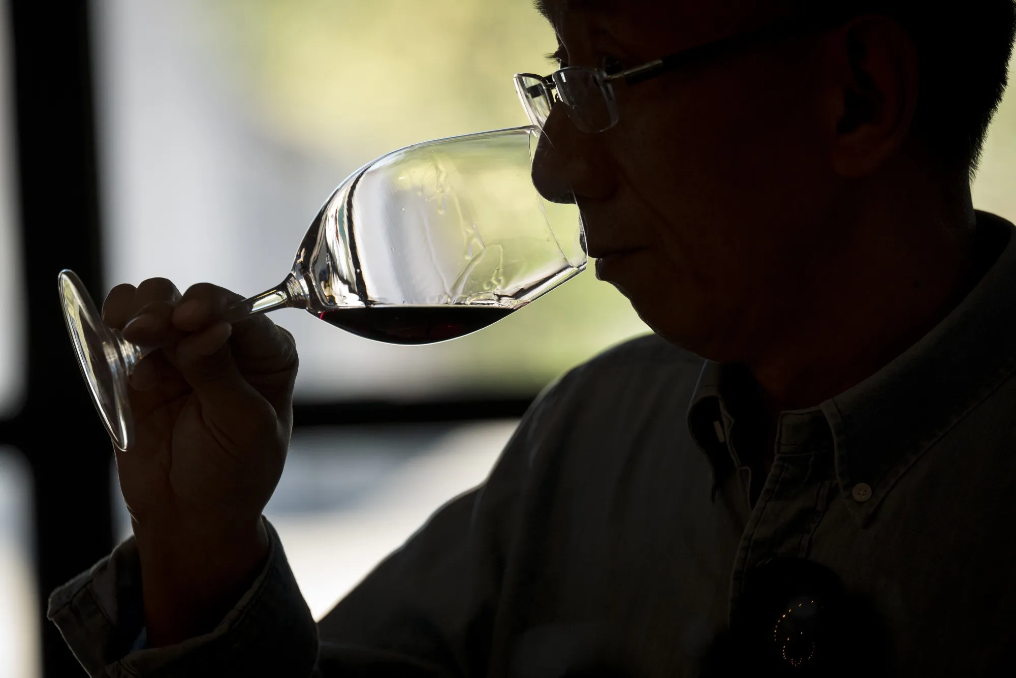A patron smells wine at the Yao Family Wines tasting room in St. Helena, California, U.S., on Saturday, June 29, 2019.